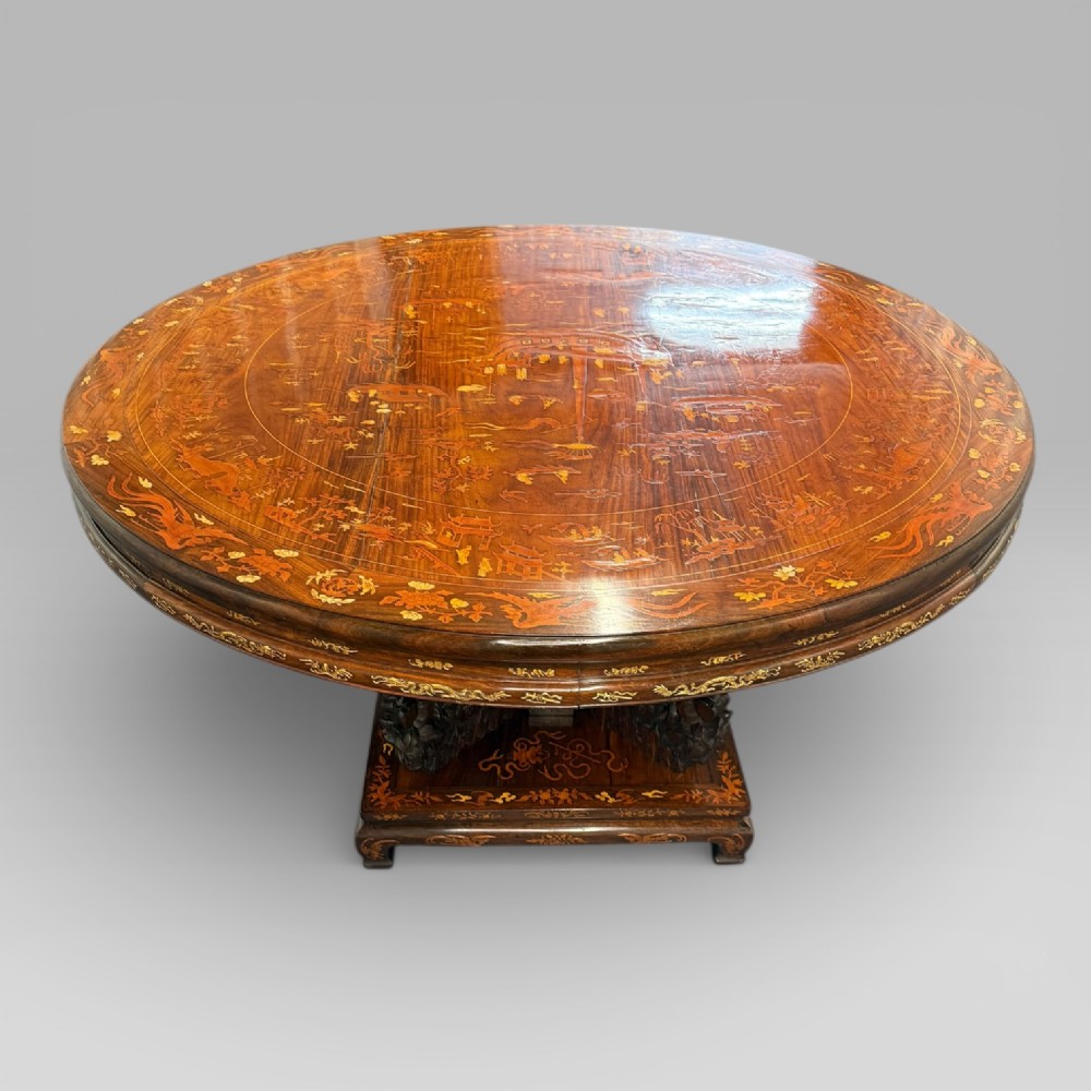 A circular dark rosewood centre table featuring detailed marquetry inlays depicting ships, pagodas, and flora. View III