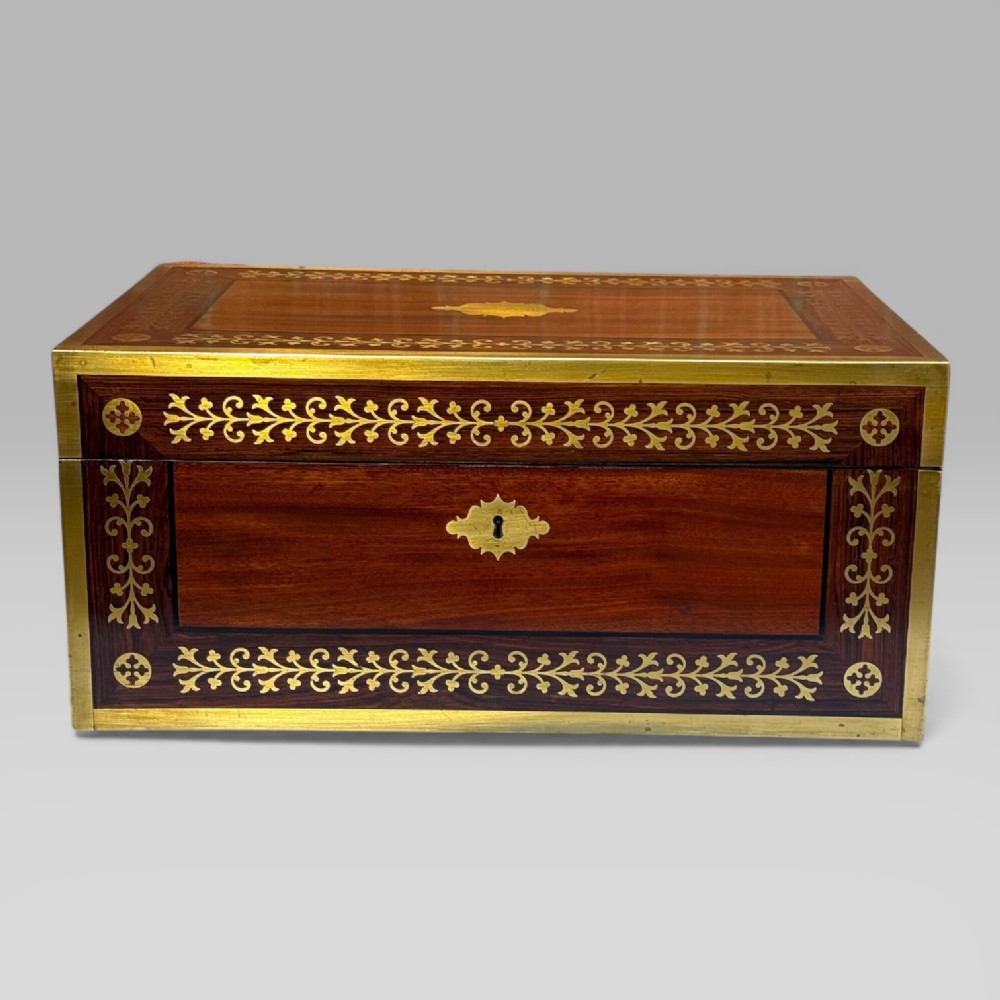 A rectangular mahogany and rosewood writing slope featuring brass bound edges, foliate brass inlay borders, a keyhole escutcheon, and an engraved brass cartouche. View II