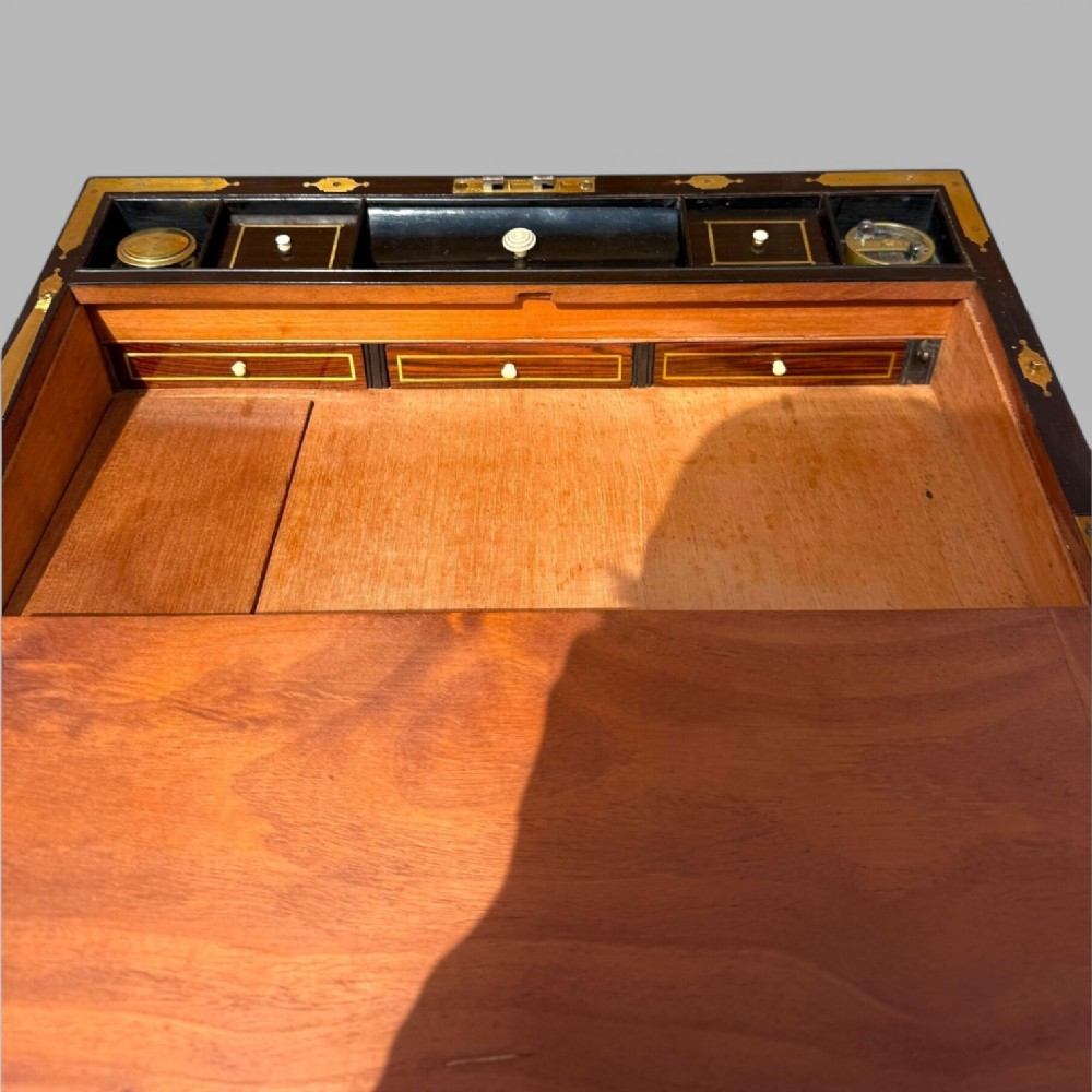 A rectangular mahogany and rosewood writing slope featuring brass bound edges, foliate brass inlay borders, a keyhole escutcheon, and an engraved brass cartouche. View XIII
