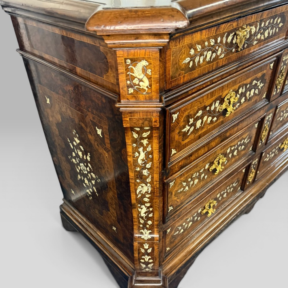 An Italian Baroque walnut commode featuring floral bone inlays across six drawer fronts, side panels, and top surface, supported by bracket feet. View VIII