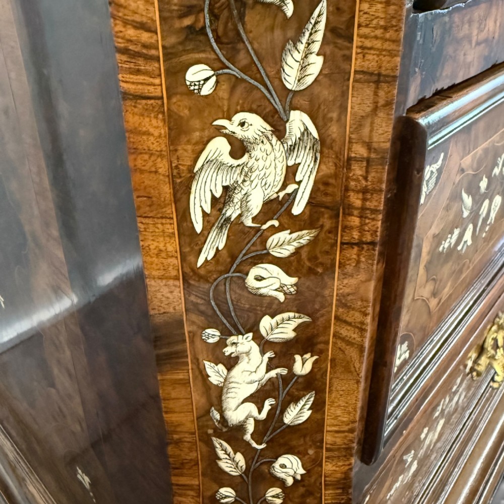 An Italian Baroque walnut commode featuring floral bone inlays across six drawer fronts, side panels, and top surface, supported by bracket feet. View IX