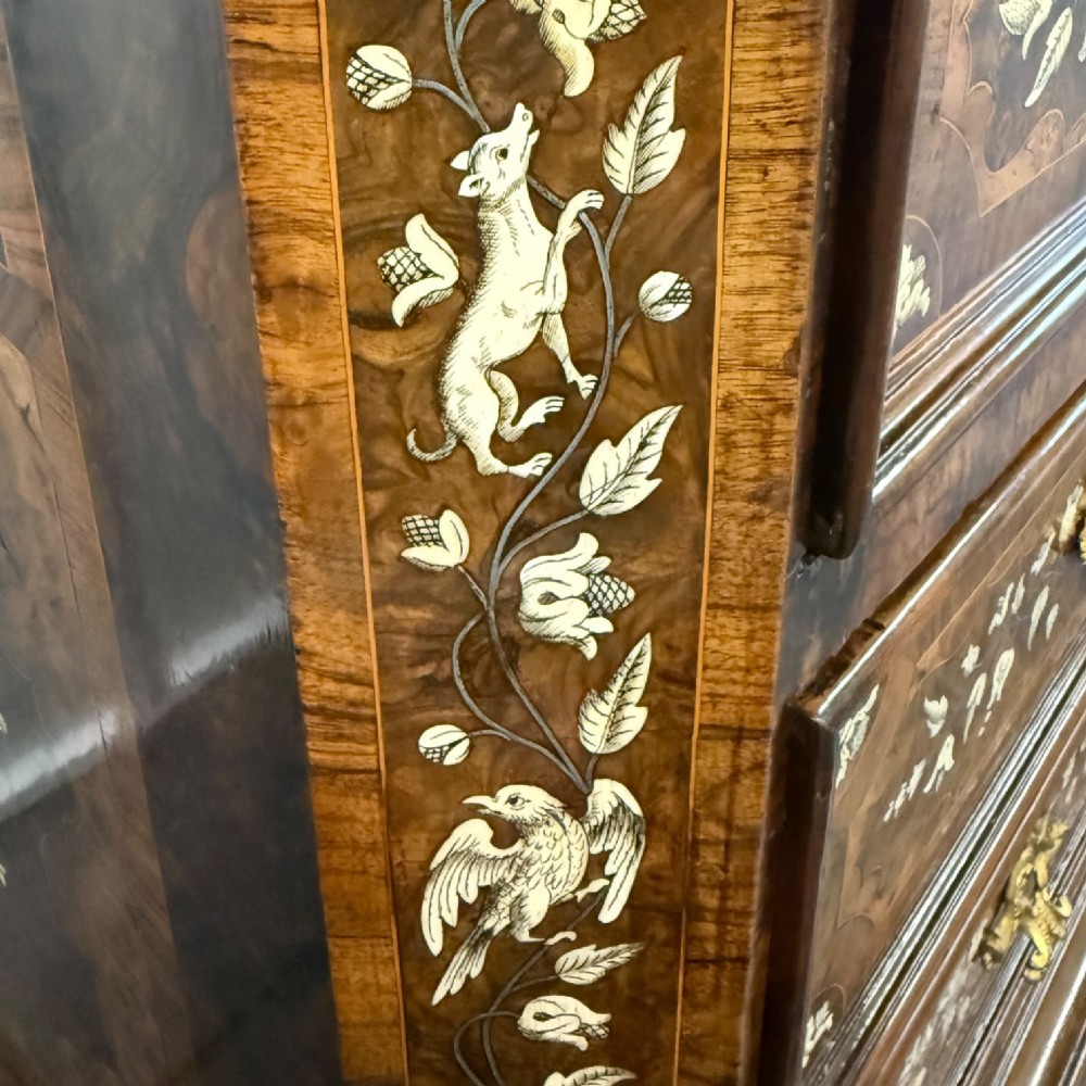 An Italian Baroque walnut commode featuring floral bone inlays across six drawer fronts, side panels, and top surface, supported by bracket feet. View X