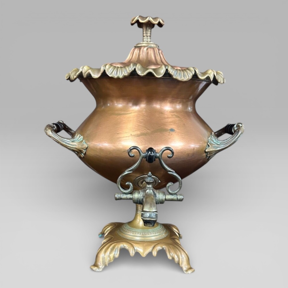 Top-down view of an antique Victorian copper samovar showing a crimped outer rim and a central heating pipe surrounded by a perforated metal interior. View II