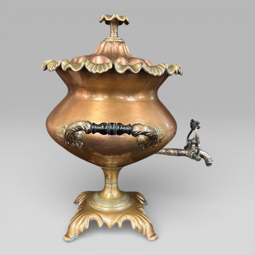 Top-down view of an antique Victorian copper samovar showing a crimped outer rim and a central heating pipe surrounded by a perforated metal interior. View III