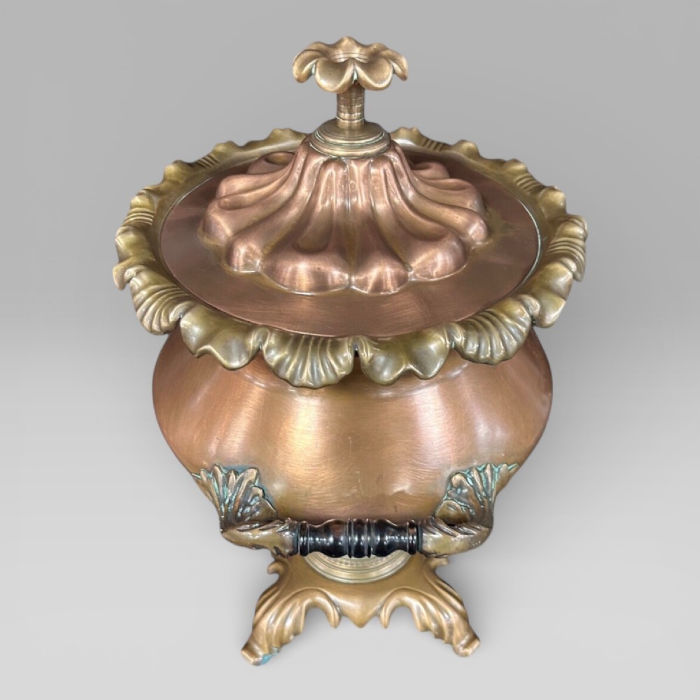 Top-down view of an antique Victorian copper samovar showing a crimped outer rim and a central heating pipe surrounded by a perforated metal interior. View IV