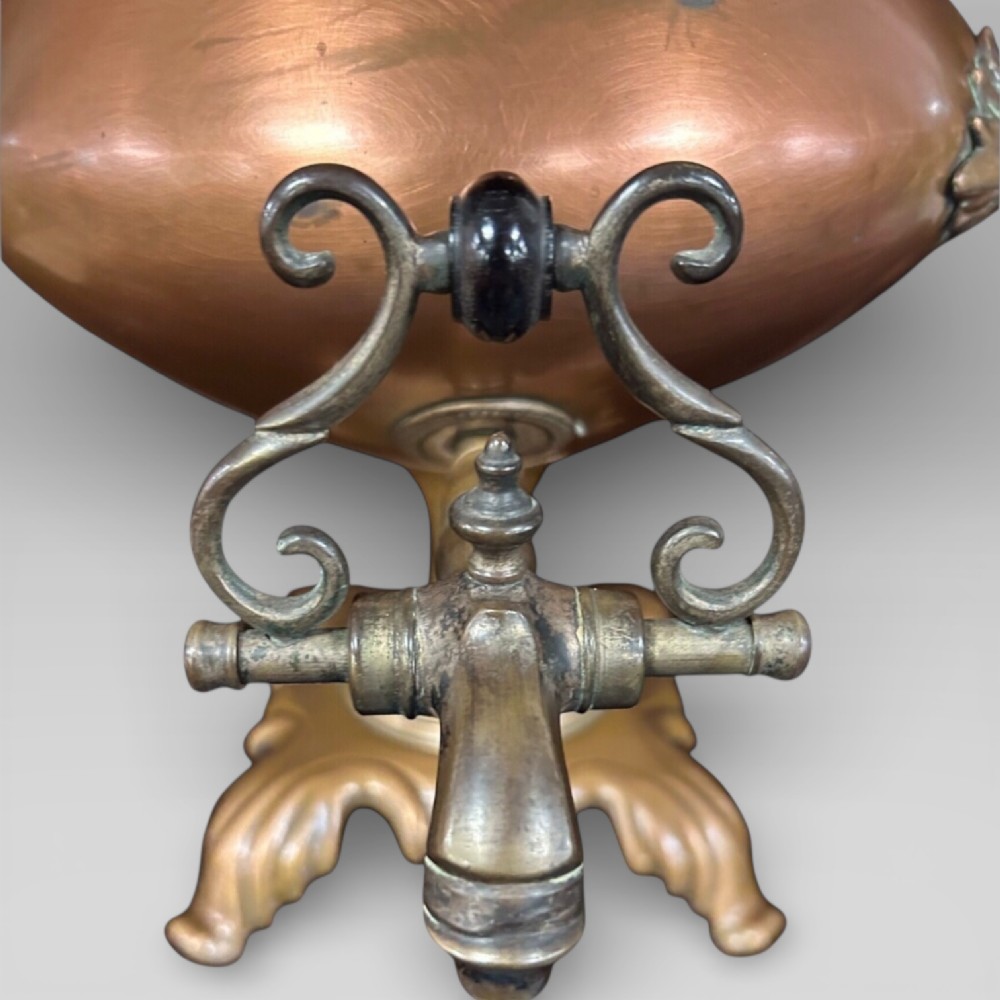 Top-down view of an antique Victorian copper samovar showing a crimped outer rim and a central heating pipe surrounded by a perforated metal interior. View V