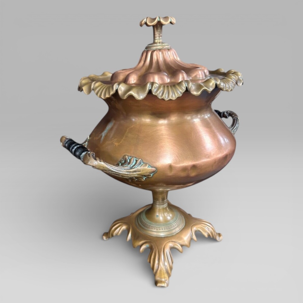 Top-down view of an antique Victorian copper samovar showing a crimped outer rim and a central heating pipe surrounded by a perforated metal interior. View VI