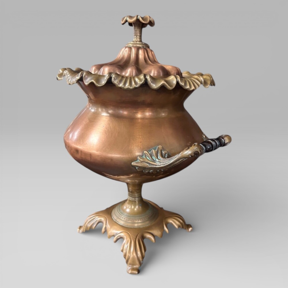Top-down view of an antique Victorian copper samovar showing a crimped outer rim and a central heating pipe surrounded by a perforated metal interior. View VII