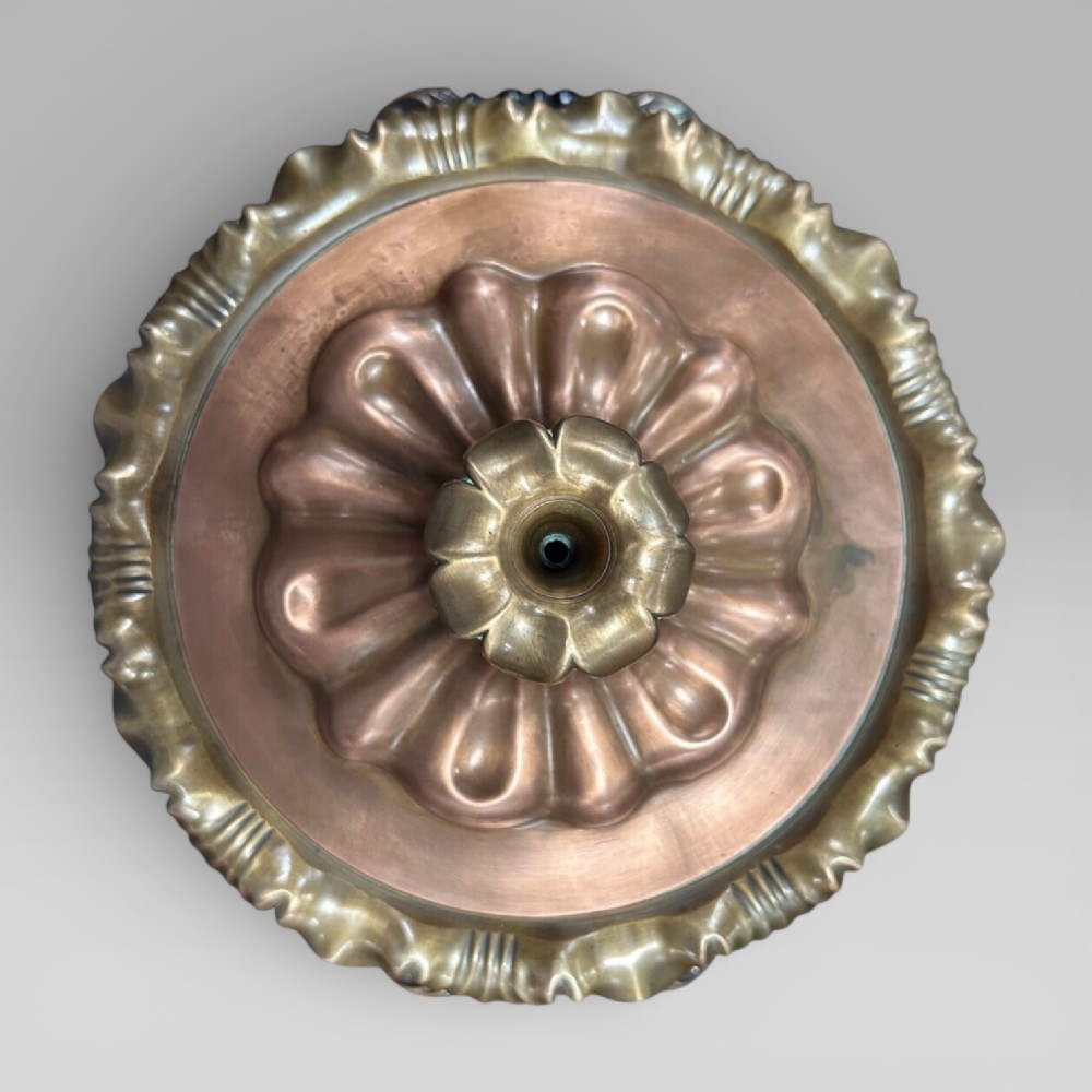 Top-down view of an antique Victorian copper samovar showing a crimped outer rim and a central heating pipe surrounded by a perforated metal interior. View IX