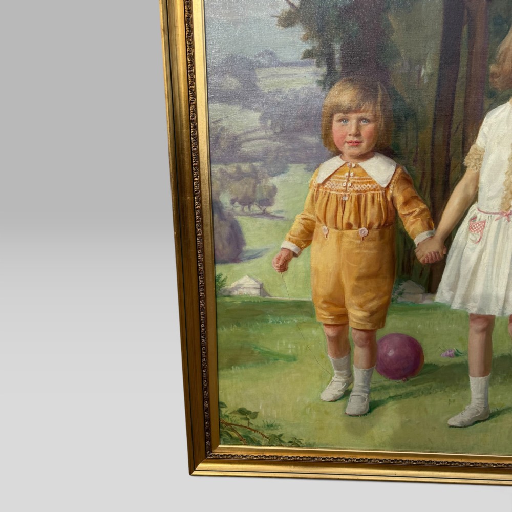 A full-length 1920s oil painting depicting two young children in a landscape setting, housed within a gilded wooden frame. View V