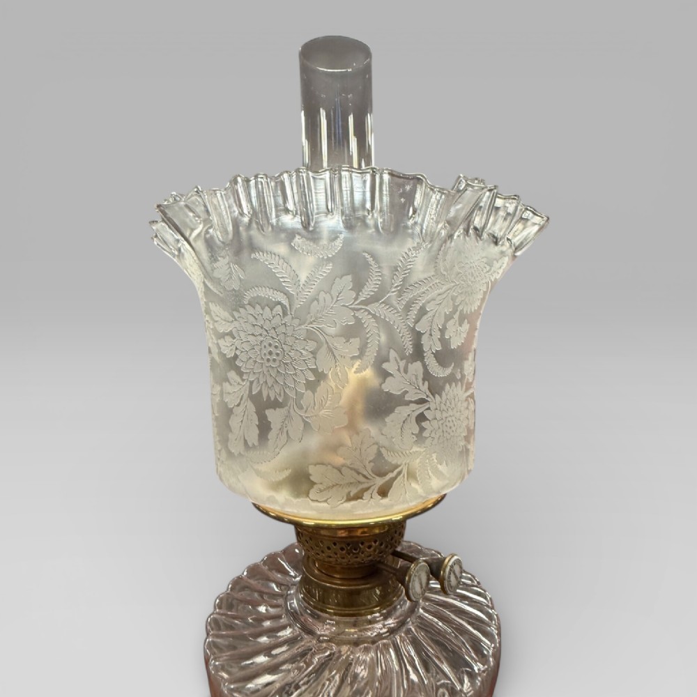 An antique Victorian oil lamp featuring a stepped brass column base, a cut glass reservoir, a duplex burner, and an etched glass tulip-shaped shade with a clear glass chimney. View IV