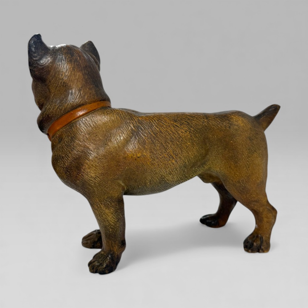 A dark brown painted terracotta dog sculpture standing upright with glass eyes and a moulded collar. View IV