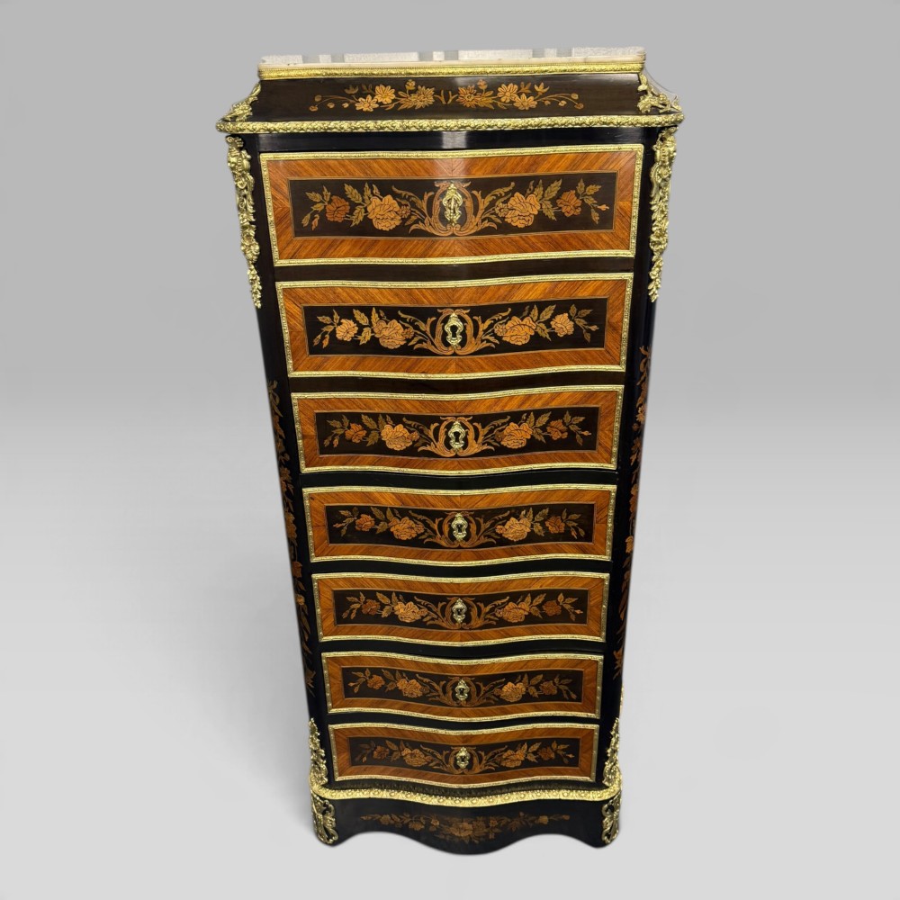 A pair of French Napoleon III narrow serpentine chests in kingwood and tulipwood featuring floral marquetry, gilt-bronze mounts, and marble tops. View IV