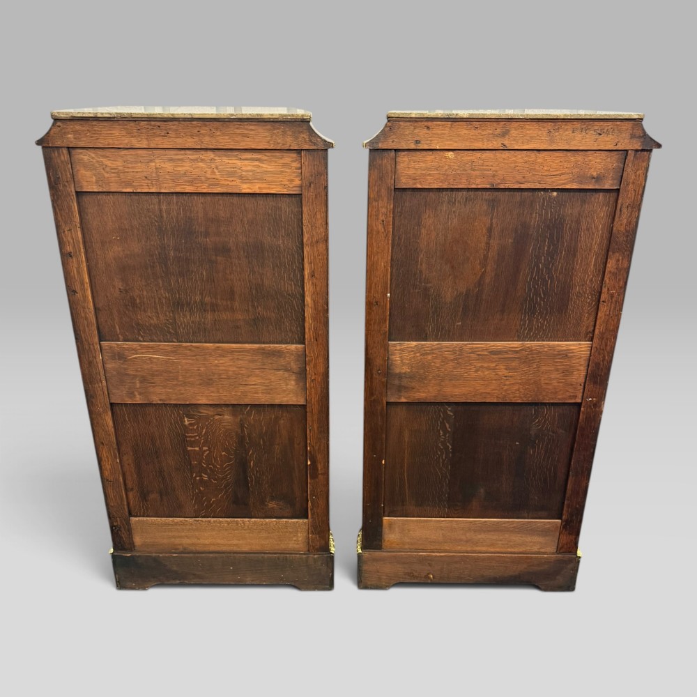 A pair of French Napoleon III narrow serpentine chests in kingwood and tulipwood featuring floral marquetry, gilt-bronze mounts, and marble tops. View VIII