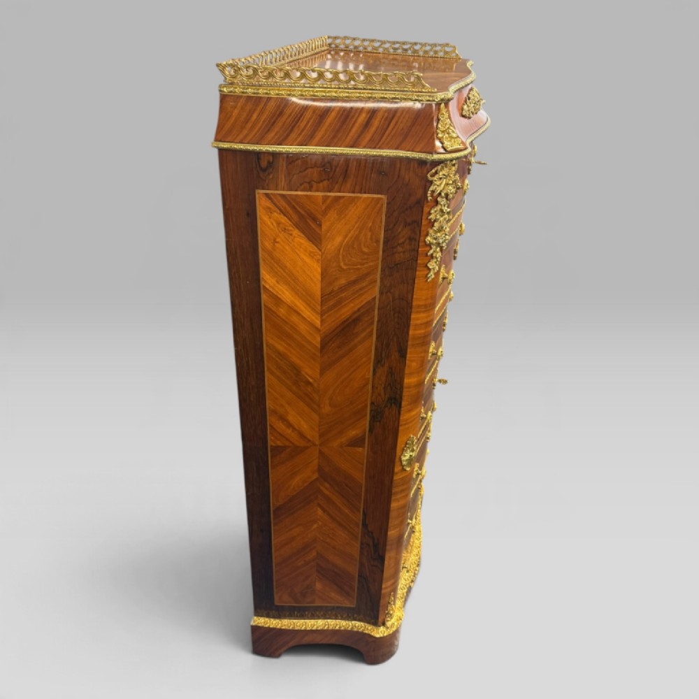 A tall antique French kingwood and rosewood secretaire chest featuring parquetry veneers, ornate gilt bronze mounts, seven drawer fronts, and a pierced brass gallery top. View VI
