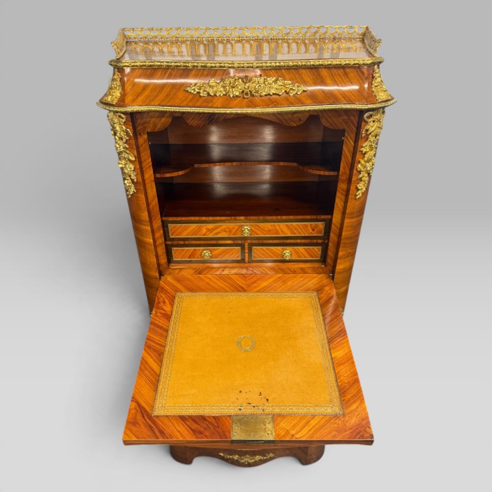 A tall antique French kingwood and rosewood secretaire chest featuring parquetry veneers, ornate gilt bronze mounts, seven drawer fronts, and a pierced brass gallery top. View VII