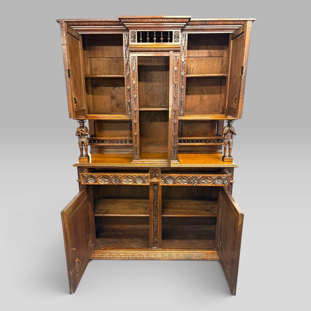 A mid-nineteenth-century dark oak French Breton buffet cabinet with detailed folk carvings, relief panels, ship wheel motifs, and carved human figure supports. View II