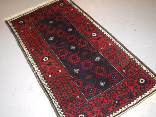 fig 1. OLD AFGHAN BALUCH RUG WITH REPEAT DESIGN AND CLASSIC BALUCH BORDER, CIRCA 1920.