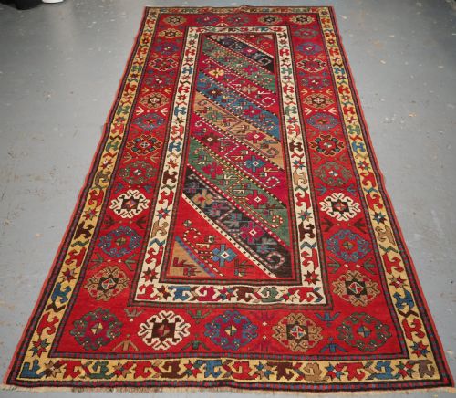 ANTIQUE CAUCASIAN GENDJE KAZAK RUG WITH DIAGONAL STRIPE DESIGN, CIRCA 1890.