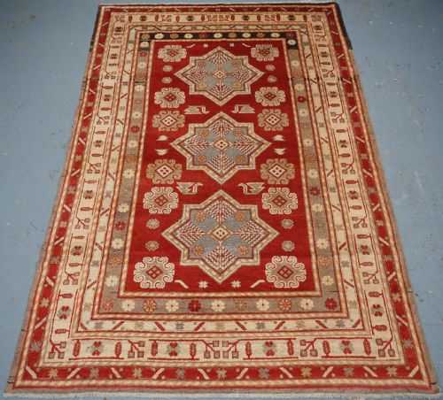 ANTIQUE EAST TURKESTAN KHOTAN RUG WITH THREE STAR MEDALLIONS, CIRCA 1920.