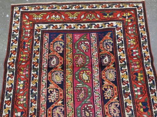 fig 1. An antique Caucasian Karabagh runner rug featuring vertical polychrome stripes filled with repeating boteh motifs framed by multiple floral borders.