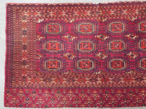 fig 1. An antique woven crimson wool Tekke Turkmen chuval face featuring twelve octagonal turreted guls arranged in a rectangular grid.