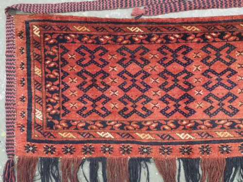 fig 1. A hand-woven antique red wool Ersari Turkmen torba featuring geometric rams horn motifs, a long fringed lower edge, and braided side straps.