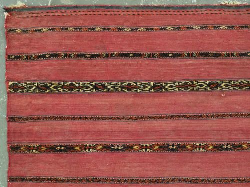 fig 1. A horizontal rectangular antique Tekke Turkmen Kizil chuval face textile woven in red wool with dark geometric striped bands.