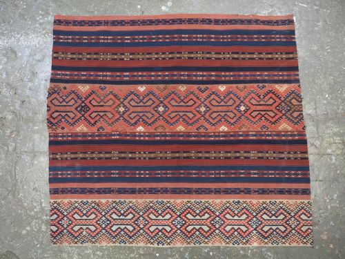 fig 1. An antique handwoven Uzbek kilim panel constructed from four joined strips featuring terracotta red, indigo blue, and ivory geometric patterns.