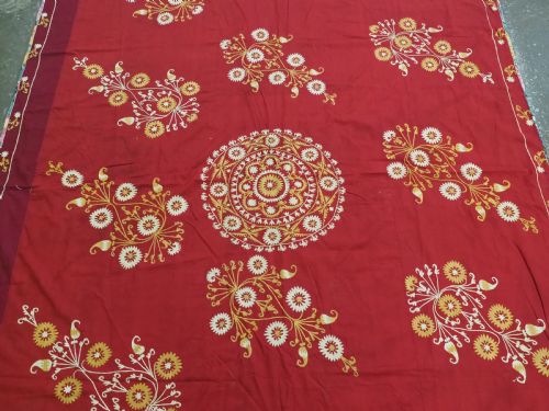 fig 2. A rectangular red adras silk and cotton textile featuring yellow and white silk thread embroidery with a central circular floral medallion, surrounding floral sprays, and a matching decorative border.