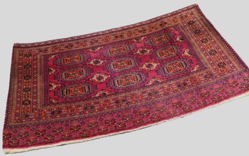 fig 1. An antique crimson red wool Tekke Turkmen chuval featuring nine central octagonal gul motifs and a plain weave back.