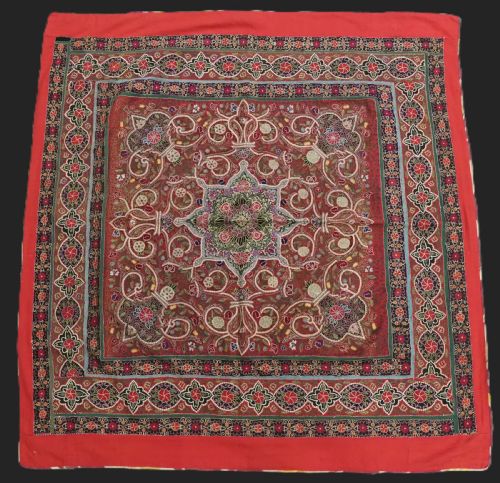fig 1. Square antique Persian Rasht embroidery featuring a central green and pink star medallion surrounded by floral motifs on red wool felt with decorative patterned borders.