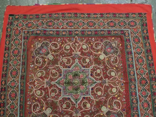 fig 3. Square antique Persian Rasht embroidery featuring a central green and pink star medallion surrounded by floral motifs on red wool felt with decorative patterned borders.