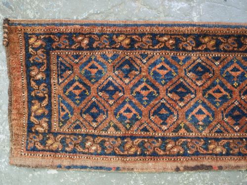 fig 1. A horizontal antique Ersari Turkmen hand-knotted wool torba face featuring repeated geometric schemle gul motifs in dark blue and terracotta red tones.