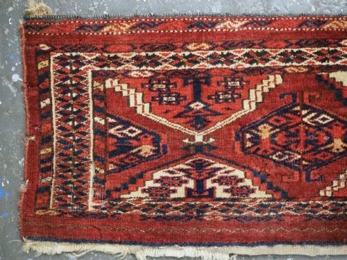 fig 1. An antique horizontal hand-woven Ersari Turkmen wool torba featuring repeating geometric diamond guls in red, white, and dark blue tones.