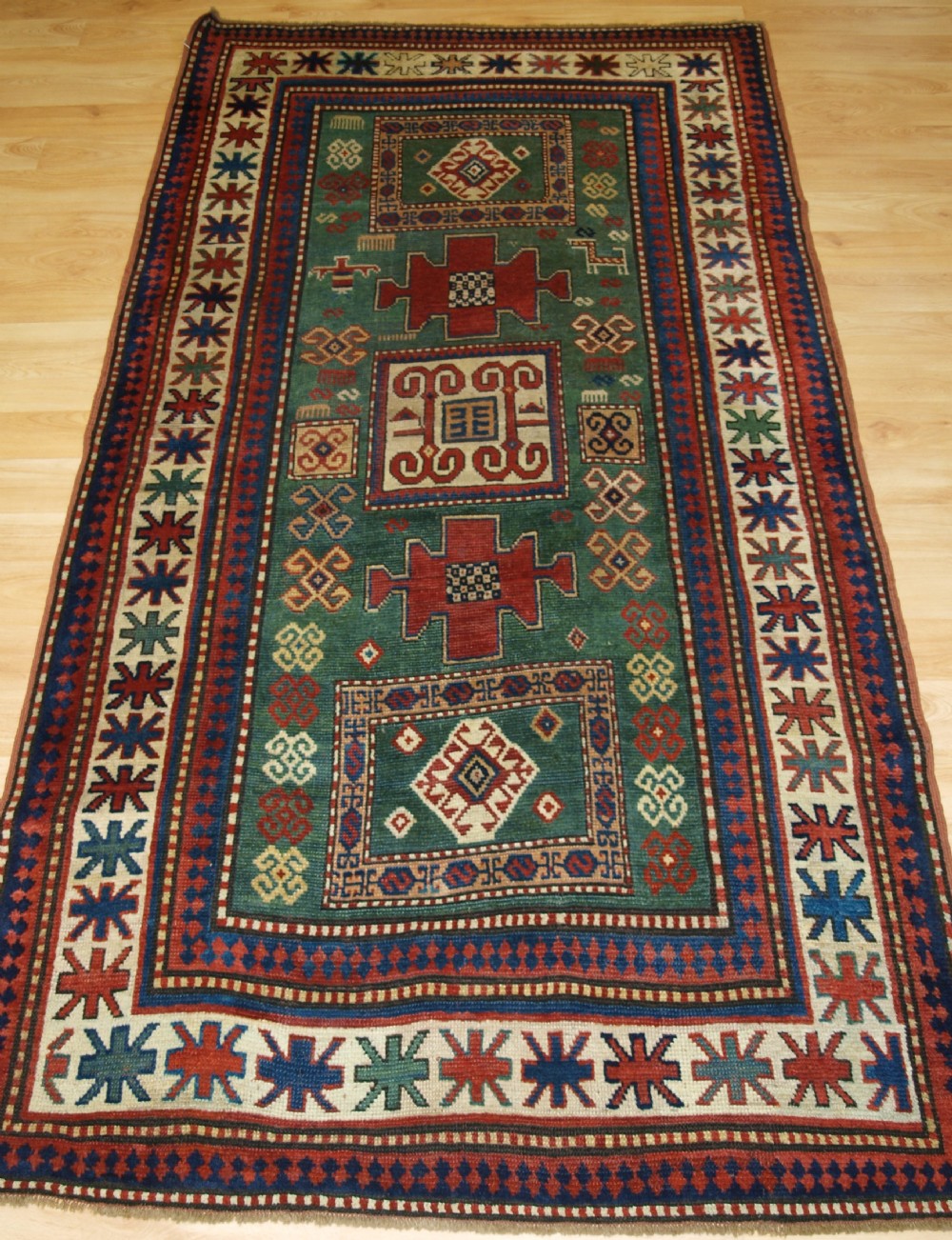ANTIQUE CAUCASIAN KARACHOV KAZAK OF RARE GREEN GROUND FORMAT, 4TH QUARTER 19TH CENTURY.