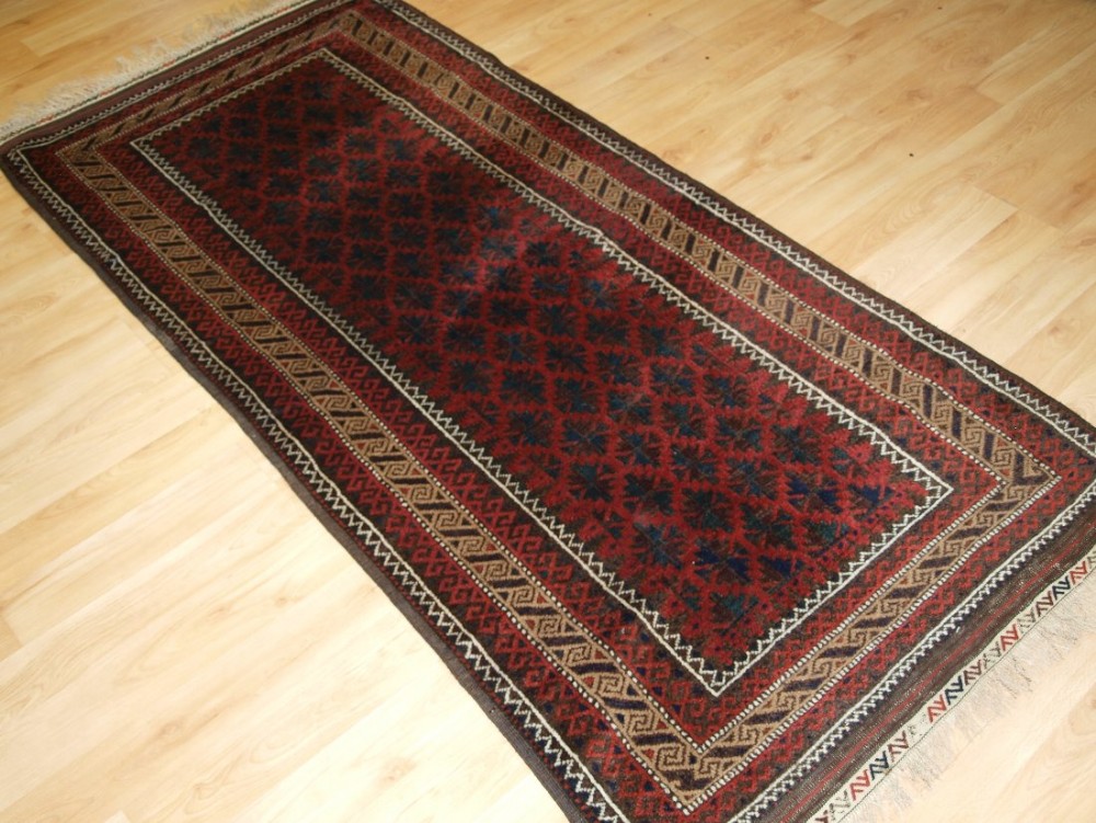 ANTIQUE BALUCH RUG WITH LATTICE DESIGN, CAMEL BORDER, KILIM ENDS, CIRCA 1900.