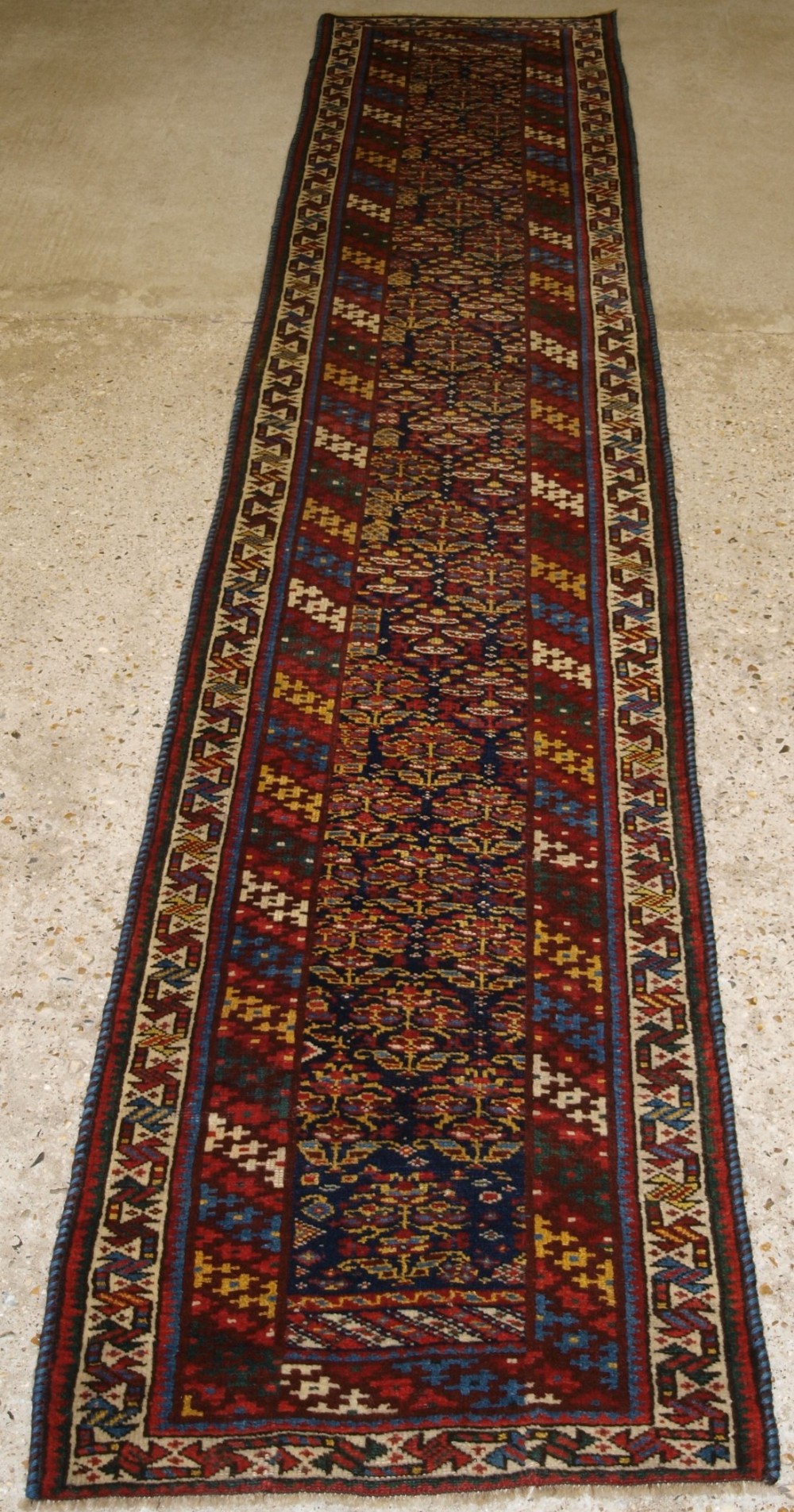 ANTIQUE SOUTH CAUCASIAN KURDISH RUNNER OF VERY NARROW WIDTH, SHRUB DESIGN, CIRCA 1900.
