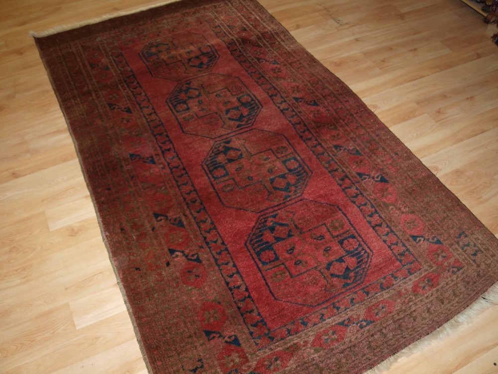 OLD AFGHAN VILLAGE RUG OF TRADITIONAL DESIGN, SOFT ROSE RED COLOUR, CIRCA 1920.