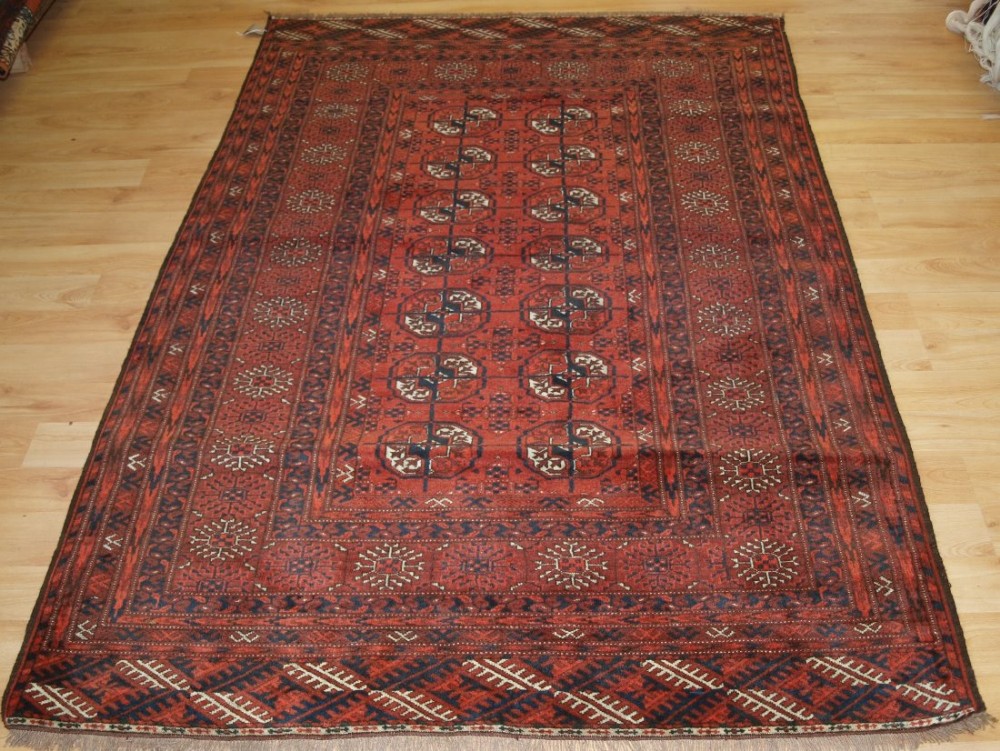OLD AFGHAN RUG OF TRADITIONAL TURKMEN DESIGN, SOFT RED COLOUR, CIRCA 1920.