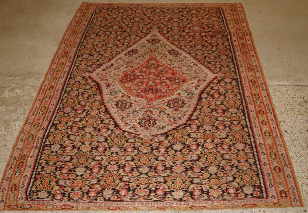 ANTIQUE PERSIAN SENNEH KILIM, UNUSUAL MEDALLION DESIGN ON A HERATTI FIELD, CIRCA 1900.