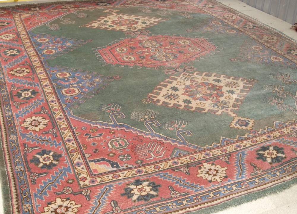 ANTIQUE TURKISH OUSHAK CARPET, UNUSUAL GREEN FIELD WITH CAUCASIAN DESIGN, CIRCA 1900/20.