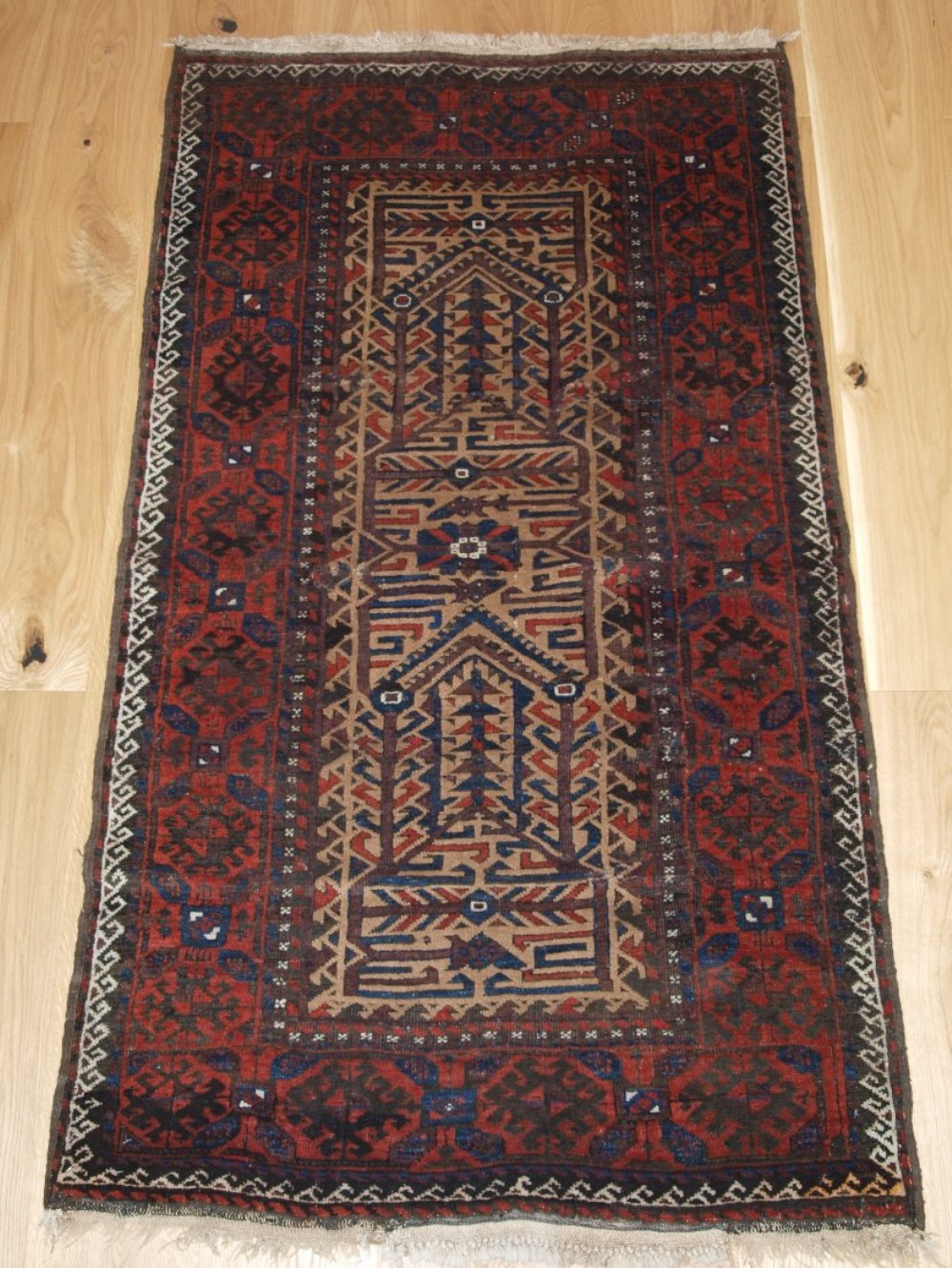 ANTIQUE BALUCH RUG WITH CAMEL GROUND AND UNUSUAL DESIGN, OLD REPAIRS, LATE 19TH CENTURY.