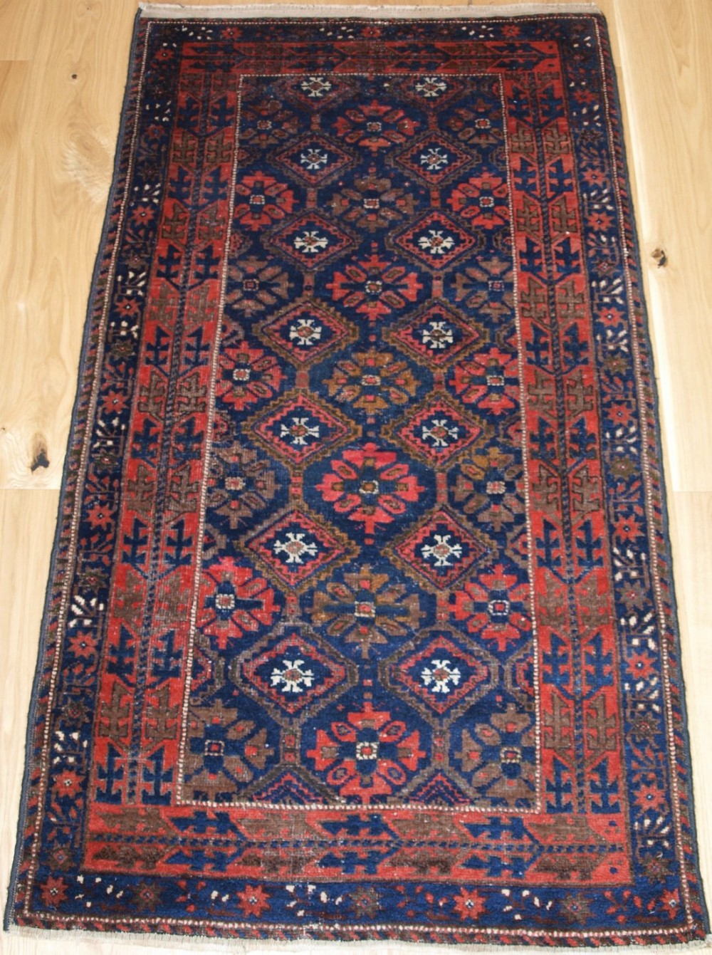 OLD BALUCH RUG WITH LATTICE DESIGN, INTERESTING BORDER, CIRCA 1920.
