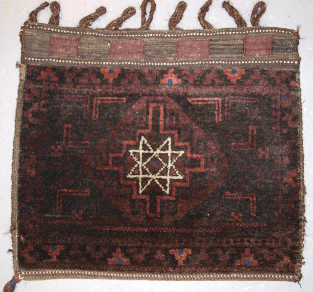 OLD AFGHAN BALUCH SADDLE BAG WITH STAR DESIGN AND PLAIN WEAVE BACK, CIRCA 1920.