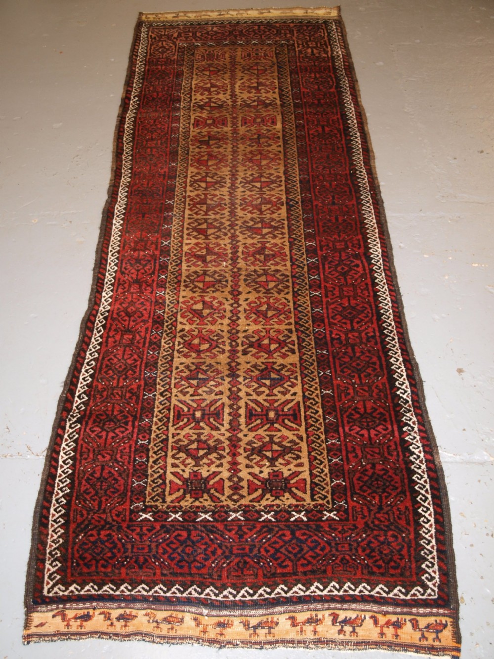ANTIQUE BALUCH RUNNER, CAMEL GROUND WITH BIRDS AT EACH END. CIRCA 1900.