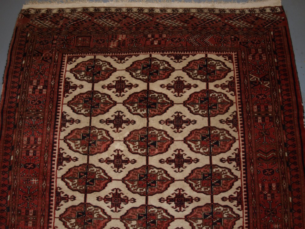 OLD AFGHAN TURKMEN RUG WITH TEKKE DESIGN ON A SCARCE IVORY GROUND. CIRCA 1920. View II