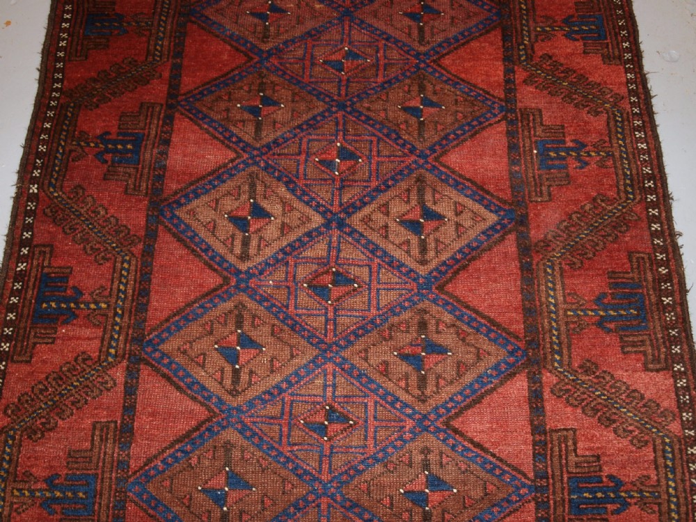 ANTIQUE AFGHAN RUG OF BALUCH LATTICE DESIGN, WARM COLOURS, CIRCA 1900/20. View IV