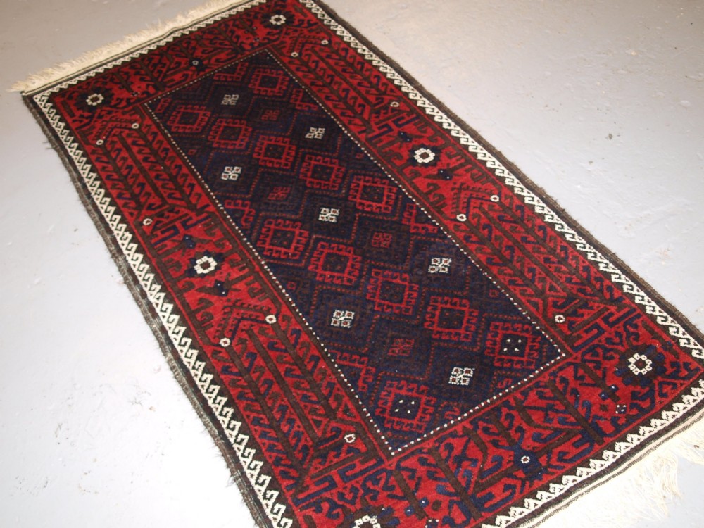OLD AFGHAN BALUCH RUG WITH REPEAT DESIGN AND CLASSIC BALUCH BORDER, CIRCA 1920. View II