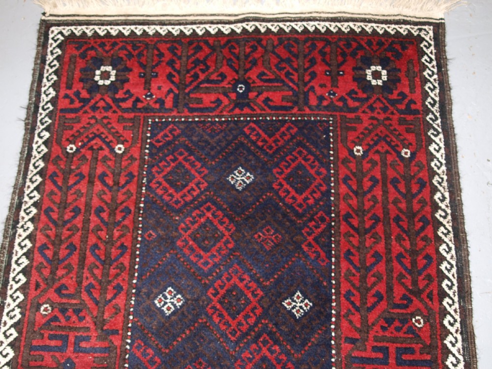 OLD AFGHAN BALUCH RUG WITH REPEAT DESIGN AND CLASSIC BALUCH BORDER, CIRCA 1920. View IV